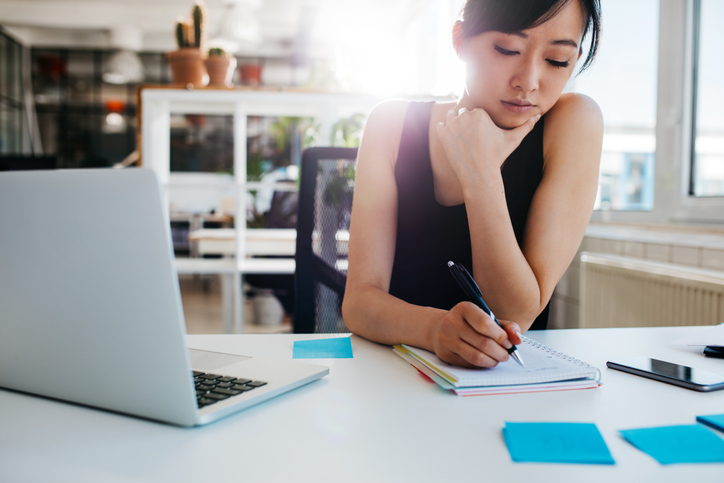 Woman writing in notepad